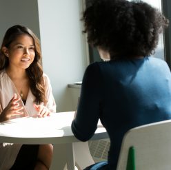 two women sitting on chair