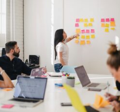woman placing sticky notes on wall