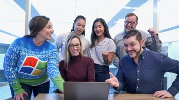woman in maroon sweater using laptop