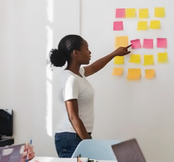 woman placing sticky notes on wall